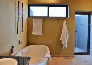 ein Bad mit einer Badewanne, einem Waschbecken und einer Dusche in der Unterkunft Mjejane Luxury Self-Catering Villa in Hectorspruit