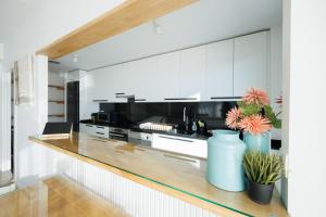 a kitchen with white cabinets and black appliances at Gran Apartmento Playa Badalona in Badalona