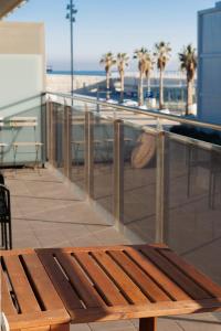 a wooden bench sitting on top of a building next to the beach at Gran Apartmento Playa Badalona in Badalona