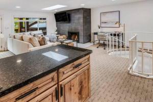 eine Küche und ein Wohnzimmer mit einem Sofa und einem Kamin in der Unterkunft New Listing 3BR 3BA Condo - Steps to Gondola in Aspen