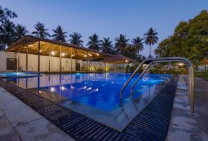 a swimming pool at night with a resort at The Vanya Luxury Boutique Resort in Bangalore