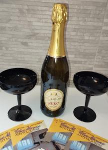 Una botella de champán con dos copas de vino en Blue Marine di Ostia en Lido di Ostia