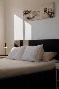 バダロナにあるGran Apartmento Playa Badalonaのベッドルーム(白いシーツと枕付)