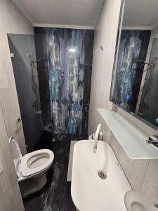 La salle de bains est pourvue d'un lavabo blanc et de toilettes. dans l'établissement Studio Apartament 47А- Trakia 54 А, à Plovdiv