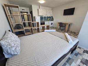 a bedroom with a large bed and a kitchen at Studio Apartament 47А- Trakia 54 А in Plovdiv