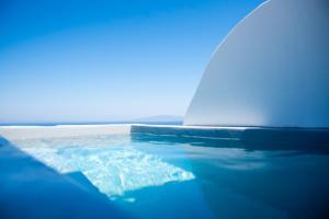 a close up of a boat in the water at White Cave Villas in Oia