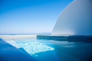 un primer plano de un barco en el agua en White Cave Villas, en Oia