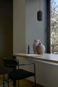 einen Stuhl und Vasen auf einer Theke in einem Zimmer in der Unterkunft Athens Woo Suites in Athen