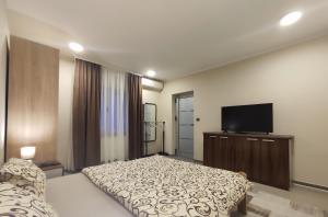 Schlafzimmer mit einem Bett und einem Flachbild-TV in der Unterkunft Prenoćište Lana in Novi Banovci