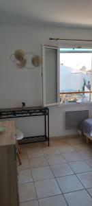 a kitchen with a window and a tiled floor at Dolce Notte in Saintes-Maries-de-la-Mer