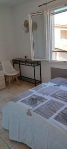 サントマリー・ド・ラメールにあるDolce Notteの窓とテーブルが備わる部屋のベッド1台分です。