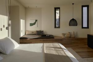 Athens Woo Suites في أثينا: غرفة نوم بسرير وطاولة ونوافذ