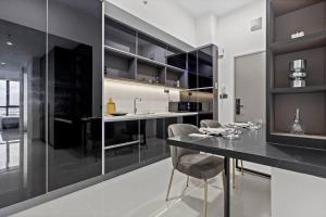 une cuisine avec des armoires noires, une table et des chaises dans l'établissement Novo Ampang, Glengeagles Executive Suite, à Kuala Lumpur