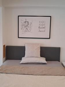 uma cama num quarto com uma fotografia na parede em Souterrain-Apartment in Wehlheiden Kassel em Kassel