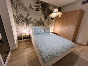 een slaapkamer met een bed en een muur met planten bij Apartman in Platan Garden in Balatonboglár