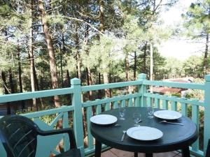 ein Tisch mit Tellern und Weingläsern auf einer Veranda in der Unterkunft Logement entier : appartement en résidence - Lacanau, France in Lacanau