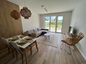een woonkamer met een tafel en een bank bij Apartman in Platan Garden in Balatonboglár