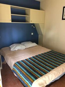 ein Schlafzimmer mit einem Bett mit blauem Kopfteil in der Unterkunft Logement entier : appartement en résidence - Lacanau, France in Lacanau + 4 Fotos