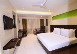 um quarto de hotel com uma cama e uma televisão em Ocean Suites Near Delhi International Airport em Nova Deli