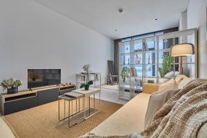 a living room with a couch and a tv at Luxury Studios with Burj Khalifa or Canal View in Downtown - Marquise Square Tower in Dubai