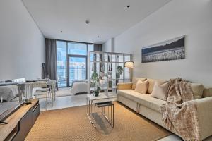 a living room with a couch and a table at Luxury Studios with Burj Khalifa or Canal View in Downtown - Marquise Square Tower in Dubai