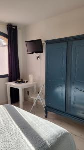1 dormitorio con cama azul y escritorio en Auberge de la Table Ronde en Vinon-sur-Verdon