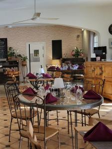 un comedor con mesas y sillas y copas de vino en Auberge de la Table Ronde en Vinon-sur-Verdon