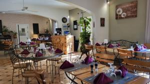 un comedor con mesas y sillas con servilletas púrpuras en Auberge de la Table Ronde, en Vinon-sur-Verdon