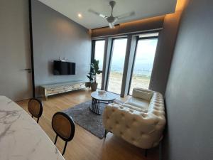 a living room with a couch and a table and a television at Penang Amazing SeaView Private Lift 梹城富人区绝美海景公寓私人电梯 in Tanjong Tokong