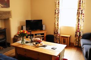 a living room with a coffee table and a television at Pet-Friendly Logburner Horse Stable Views in Hay-on-Wye
