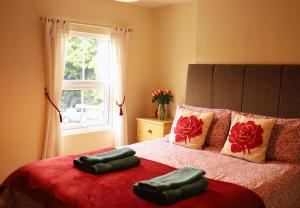 a bedroom with a bed with two pillows and a window at Pet-Friendly Logburner Horse Stable Views in Hay-on-Wye
