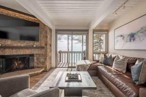 a living room with a couch and a fireplace at Renovated 2 BR Condo w Hot Tub -Mountain Views! in Snowmass Village