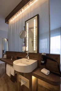 ein Bad mit einem Waschbecken und einem Spiegel in der Unterkunft Hotel Alte Mark in Hamm