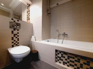 a bathroom with a toilet and a bath tub at Apartament z podziemnym parkingiem ulica Wroclawska in Krakow