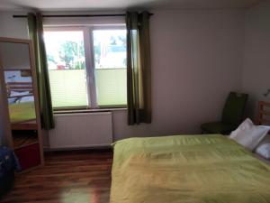 a bedroom with a bed and a large window at Ferienwohnung Am Hausberg in Radebeul in Radebeul