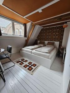 Habitación con 2 camas, mesa y ventana en Drostenstraat (voor groepen), en Zwolle