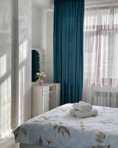 una camera da letto con un letto e asciugamani di Kojomkul a Bishkek