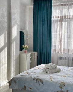 Un dormitorio con una cama con toallas. en Kojomkul, en Bishkek