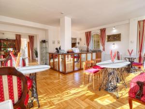 un soggiorno con tavoli e sedie e una cucina di Villa Panoráma a Eger