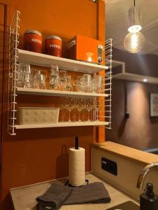 a kitchen with a counter with glasses on shelves at Drostenstraat (voor groepen) in Zwolle