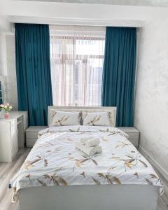 a bedroom with a large bed with blue curtains at Kojomkul in Bishkek