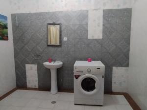 a bathroom with a washing machine and a sink at Residencia BB in Praia