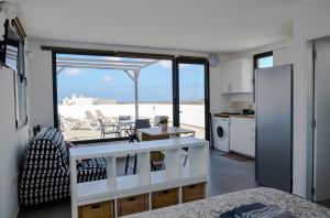 a kitchen and living room with a view of the beach at NaoClub Fuerteventura in Lajares