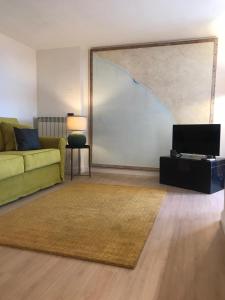 a living room with a green couch and a television at Friendly House 94 in Rome