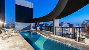 a swimming pool on the roof of a building at Hotel Slavieiro Moema Suite Prime Familia in Sao Paulo