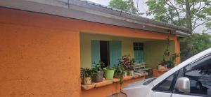 an orange house with plants on a window sill at Sipili Village Residence in Nyahururu