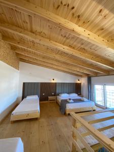 two beds in a large room with wooden ceilings at Sea's Villa in Ksamil