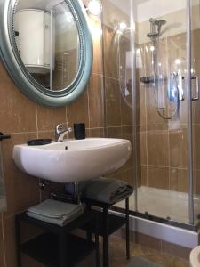 a bathroom with a sink and a mirror and a shower at Friendly House 94 in Rome