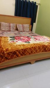 a bed with a wooden frame with flowers on it at Laxmi home stay in Ghūra