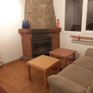 sala de estar con sofá y chimenea en Casa en Pinilla de Buitrago, en Gargantilla del Lozoya